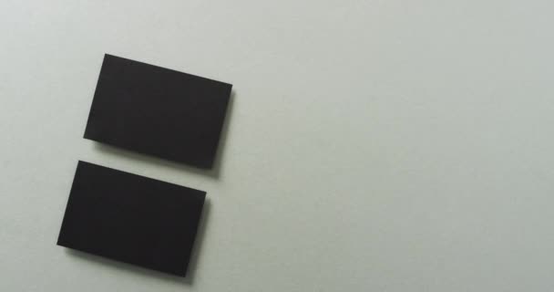 俯瞰两张黑色名片的灰色背景 复制空间 慢动作 联系方式 设计模板 — 图库视频影像
