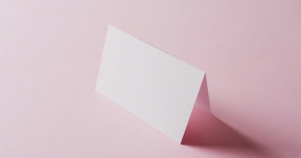 Close Van Twee Blanco Witte Visitekaartjes Roze Achtergrond Kopieerruimte Slow — Stockvideo