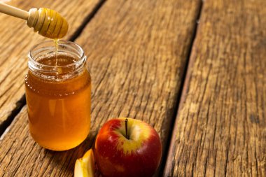 Bal kavanozu ve ahşap masada elma ve bal kavanozu manzarası, kopyalama alanı. Değiştirilmemiş, tatlı yiyecek, meyve, yiyecek, sağlıklı ve sonbahar mevsimi konsepti.