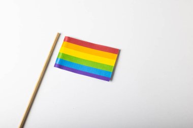 Beyaz arka planda izole edilmiş gökkuşağı bayrağının yüksek açılı görüntüsü, kopyalama alanı. Lgbtqia hakları, özgürlük, eşitlik, gurur kavramı.