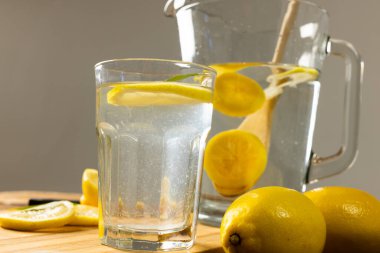 Sürahi yakın plan ve limonata ile gri arka plan, fotokopi alanı. Kesme tahtası, içecek, sarı, turunçgil, yiyecek, sağlıklı konsept.