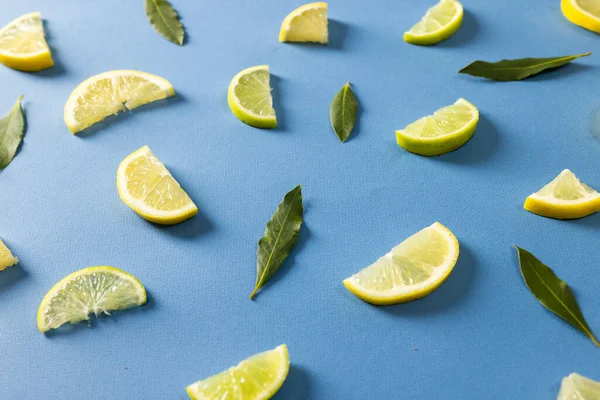 Hochwinkelblick Auf Zitronenscheiben Mit Blättern Vor Blauem Hintergrund Kopierraum Grün — Stockfoto