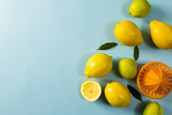 Overhead Ansicht Von Zitronen Mit Blättern Und Quetsche Über Blauem — Stockfoto
