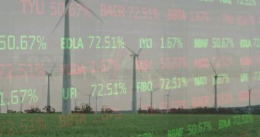 Gri gökyüzüne karşı çayırlarda dönen yel değirmenlerinin üzerinde işlenen borsa verilerinin animasyonu. Küresel ekonomi ve yenilenebilir enerji teknolojisi kavramı