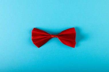 Kırmızı papyonun yukarıdan görünüşü mavi arkaplan ile izole edilmiş, kopyalama alanı. Erkek giyim, moda ve zarafet konsepti.