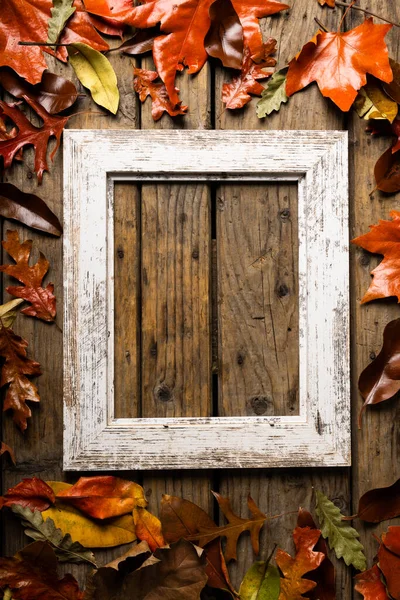 Widok Pusty Stary Obraz Ramki Jesiennymi Liśćmi Nad Drewnianym Stołem — Zdjęcie stockowe