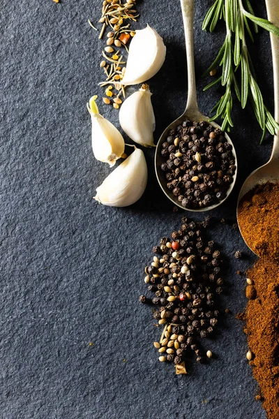 ブラック大理石のテーブルの上に黒コショウ グランドスパイス ニンニク ローズマリーのショットの真上 変更されていない食品成分調味料の概念 — ストック写真