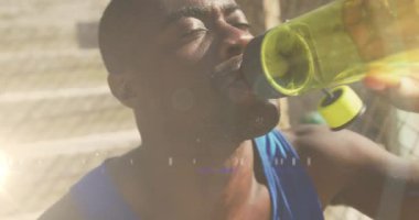 Afrika kökenli Amerikalı bir adamın su içmesi üzerine parlayan ışıkların animasyonu. Küresel bağlantılar, refah, zindelik ve dijital olarak üretilen sağlıklı yaşam tarzı konsepti.