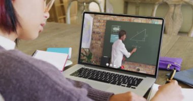 Ekranda beyaz erkek öğretmenle çevrimiçi ders için bilgisayar kullanan melez bir kız öğrenci. İletişim, teknoloji, okul, öğrenme ve çevrimiçi eğitim, dijital kompozit video.