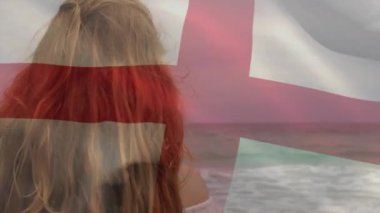 İngiliz bayrağının animasyonu. Sahilde duran güzel, melez kadının üzerinde sallanıyor. Dijital bileşim, çoklu pozlama, tatil, boş zaman, özgürlük ve vatanseverlik kavramı.