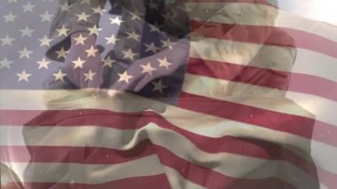 Beyaz arka planda beyaz önlüklü beyaz asker çantasının üzerinde Amerikan bayrağı sallama animasyonu. Dijital bileşim, çoklu pozlama, gurur, ordu, silahlı kuvvetler ve vatanseverlik kavramı.