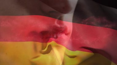 Beyaz adamın yakın plan portresi üzerinde Alman bayrağı sallamanın animasyonu. Dijital kompozit, çoklu pozlama, özgürlük, soyut ve vatanseverlik kavramı.