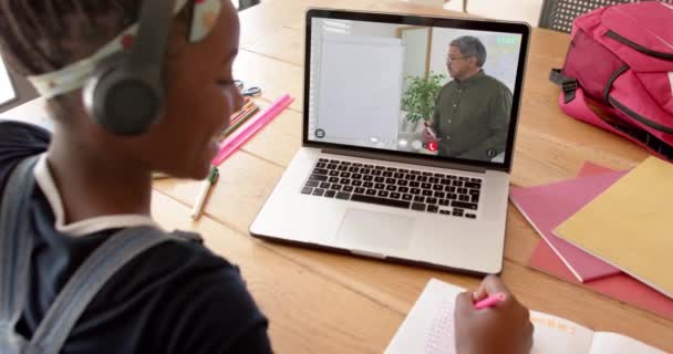アフリカ系アメリカ人の女子学生がラップトップを使ってオンラインレッスンをしています コミュニケーション テクノロジー 学習とオンライン教育 デジタル複合ビデオ — ストック動画