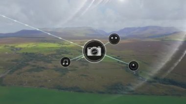 Çizgilerle bağlı ikonların animasyonu, dağlara karşı yeşil alanın havadan görünüşü ve bulutlu gökyüzü. Dijital bileşik, çoklu pozlama, iletişim, manzara, doğa ve teknoloji kavramı.