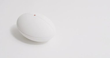 Beyaz arka planda beyaz rugby topu, fotokopi alanı, yavaş çekim. Rugby, spor, yarışma ve oyunlar dijital olarak oluşturuldu.