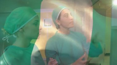 Çeşitli kadın cerrahların hastanın röntgen raporlarını incelediği Nijerya bayrağının dalgalanması. Dijital bileşim, çoklu pozlama, takım çalışması, sağlık, özgürlük ve vatanseverlik kavramı.