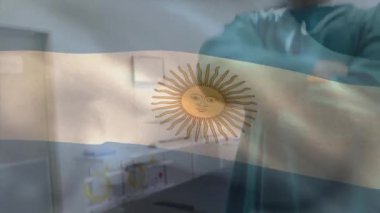 Ameliyat odasında kollarını kavuşturmuş beyaz cerrah üzerinde sallanan Arjantin bayrağının animasyonu. Dijital bileşik, çoklu pozlama, tıbbi, sağlık, özgürlük ve vatanseverlik kavramı.