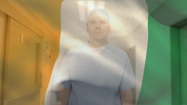 Animación Bandera Costa Marfil Cirujano Caucásico Ajustando Guantes Corriendo Quirófano — Vídeos de Stock