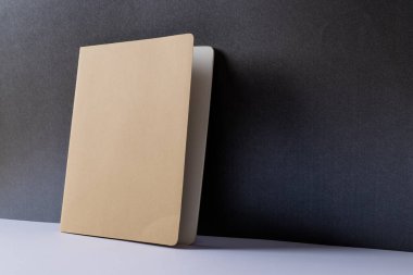 Siyah arkaplanda kopya alanı olan bej bir defter kapat. Edebiyat, okuma, yazma, boş zaman ve kitaplar..