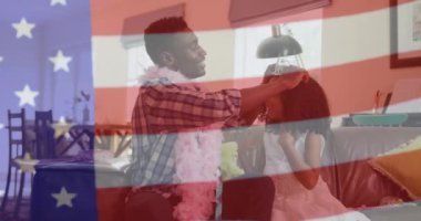 Afro-Amerikan baba ve kızının ABD bayrağı üzerinde evde canlandırılması. Amerikan vatanseverliği, bağımsızlık, yaz ve çeşitlilik kavramı dijital olarak oluşturulmuş video.
