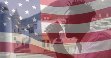 Amerikan bayrağının sallanışının animasyonu, balkonda dururken alkol içen Afrikalı Amerikalı adam. Dijital bileşim, çoklu pozlama, özgürlük, gurur, vatanseverlik, soyut ve tatil kavramı.