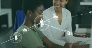 Ofisteki masaüstü raporlarını tartışan çeşitli kadın çalışanlar üzerinde bağlı simgelerin canlandırılması. Dijital bileşik, çoklu pozlama, iletişim, takım çalışması, iş ve teknoloji kavramı.