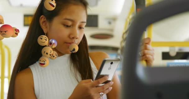 Анімація Декількох Смайликів Над Азіаткою Використовуючи Мобільний Телефон Під Час — стокове відео