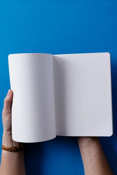 高加索女人的手拿着一本蓝色背景的书 闲暇时间和书籍 — 图库照片