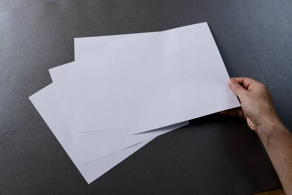 Beyaz Bir Kadının Elinde Kağıt Parçalarının Üzerinde Siyah Arka Planda — Stok fotoğraf
