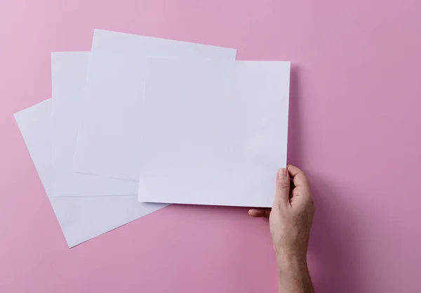 Beyaz Bir Kadının Elinde Kağıt Parçalarının Üzerinde Pembe Arka Planda — Stok fotoğraf