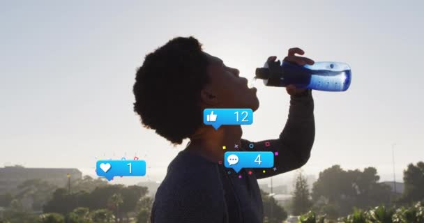 Анимация Уведомлений Икон Цифр Над Африканским Американцем Пьющим Воду Против — стоковое видео