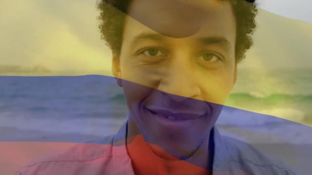 Kolombiya Bayrağının Hareketlendirilmesi Gülümseyen Afro Amerikan Bir Adamın Denize Karşı — Stok video