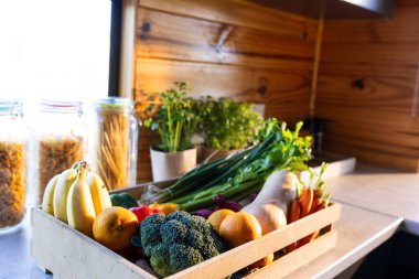 Odunluktaki güneşli mutfakta tezgahın üstünde organik sebzeler var. Yiyecek, beslenme, dengeli beslenme ve sağlıklı yaşam..