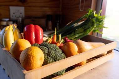 Odunluktaki güneşli mutfakta tezgahın üstünde organik sebzeler var. Yiyecek, beslenme, dengeli beslenme ve sağlıklı yaşam..