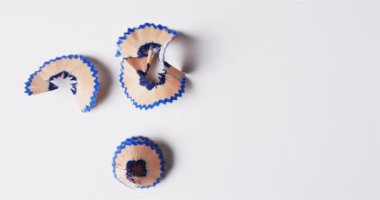 Beyaz arka planda fotokopi alanı olan mavi boya kalemlerinin yavaş çekimde yukarıdan görünüşü. Kırtasiye, öğrenim, okul ve eğitim kavramı.