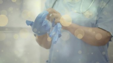 Beyaz erkek doktorun eldiven taktığı sarı noktaların animasyonu. Salgın, virüs, koruma, ilaç ve sağlık hizmetleri konsepti dijital olarak oluşturulmuş video.