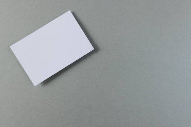 Gri arka planda fotokopi alanı olan beyaz kartvizit. İş, kartvizit, kırtasiye ve yazma alanı kavramı.