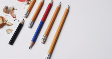 Kalemleri ve kalemtıraşı beyaz arka planda yavaş çekimde kapatın. Kırtasiye, öğrenim, okul ve eğitim kavramı.