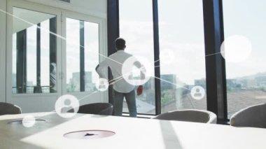 Ofiste pencereden dışarı bakan adamın dikiz aynasıyla profil simgelerinin oluşturduğu bir ağ animasyonu. Küresel ağ ve iş teknolojisi kavramı