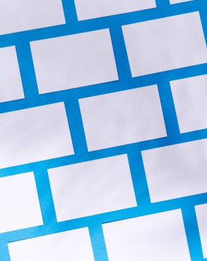 Mavi arkaplanda kopyalama alanı olan beyaz kartvizitlerin dikey görüntüsü. İş, kartvizit, kırtasiye ve yazma alanı kavramı.