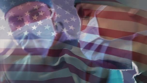 在医院进行外科手术的不同医生团队之间挥动美国国旗的动画 医疗和爱国主义概念 — 图库视频影像