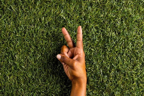 草の背景にコピースペースで平和標識を示す出生男の手のクローズアップ 平和と反戦運動の概念 — ストック写真