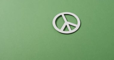 Beyaz barış işaretini kapat ve yeşil arkaplanda boşluğu kopyala. Barış ve savaş karşıtı hareket kavramı.