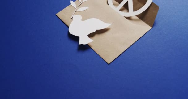 白い鳩の葉 白い平和の印 封筒を閉じ 青い背景にスペースをコピーします 平和と反戦運動の概念 — ストック動画