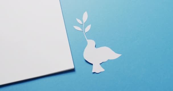 白い鳩の葉 白い紙で閉じ 青い背景にスペースをコピーします 平和と反戦運動の概念 — ストック動画