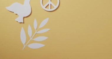 Beyaz güvercini, barış işareti, yaprak ve sarı arkaplanda kopyalama alanı ile kapatın. Barış ve savaş karşıtı hareket kavramı.