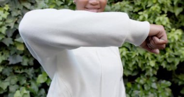 Beyaz kapüşonlu sweatshirt giyen, fotokopi çeken, ağır çekimde mutlu Afro-Amerikan kadının orta bölümü. Moda, günlük kıyafetler ve rahat kıyafetler, değiştirilmemiş..