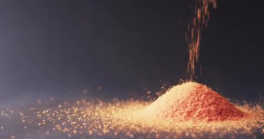 Turuncu kum tanelerinin üst üste yığılıp siyah arkaplanda kopyalanış videosu. Kum, doku ve kalıp kavramı.