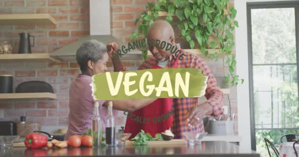 Анимация Текста Веганской Еды Над Африканской Американской Парой Готовящей Овощи — стоковое видео