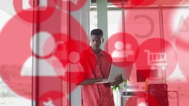 Afro-Amerikan iş adamının ofisindeki simgelerle veri işleme animasyonu. Küresel iş, dijital arayüz, hesaplama ve veri işleme kavramı dijital olarak oluşturulmuş video.